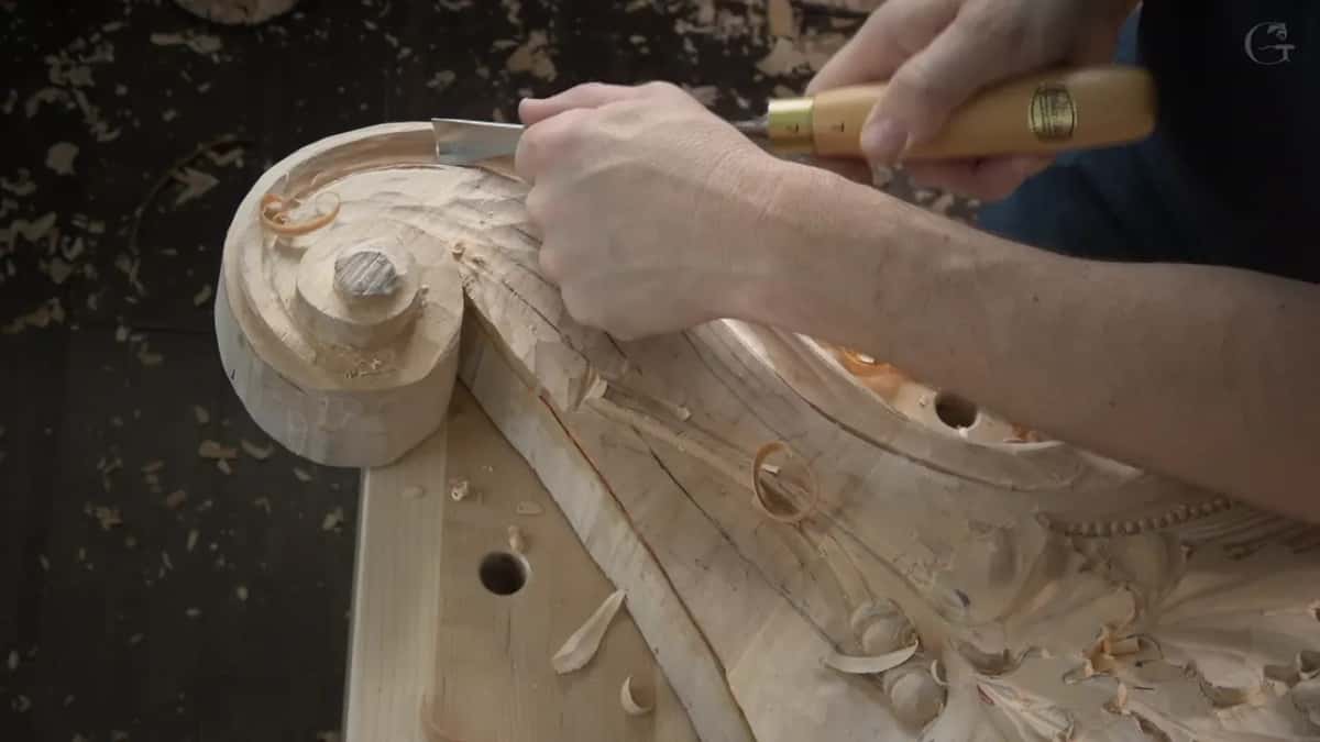 Orange curls lift off the top of the scroll while a broad gouge pushes forward.