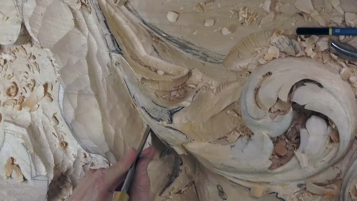 Fingers low, a narrow gouge tipped into the hollow under the long lobes.