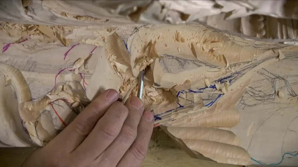 Fingers guide a narrow tool into a dug hollow
