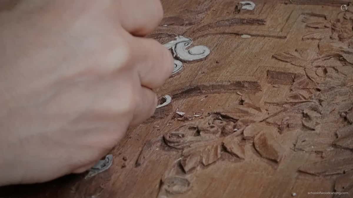 His fist over the carved leaves with the boundary being marked.