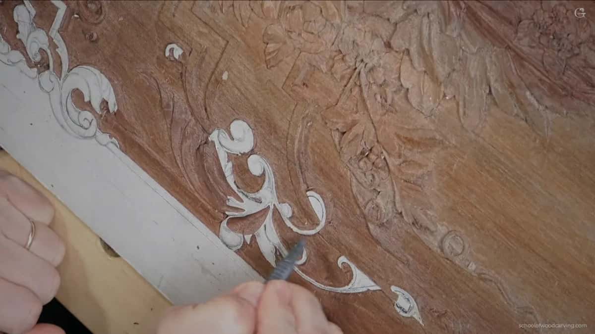 A ringed hand with a small tool at the scrolls he plans to lower today.