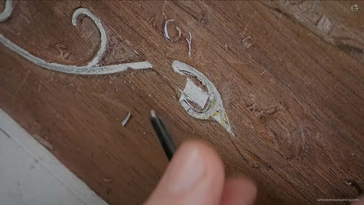 A dark tool where the leaf passes beneath the moulding and comes back over the top of it further along.