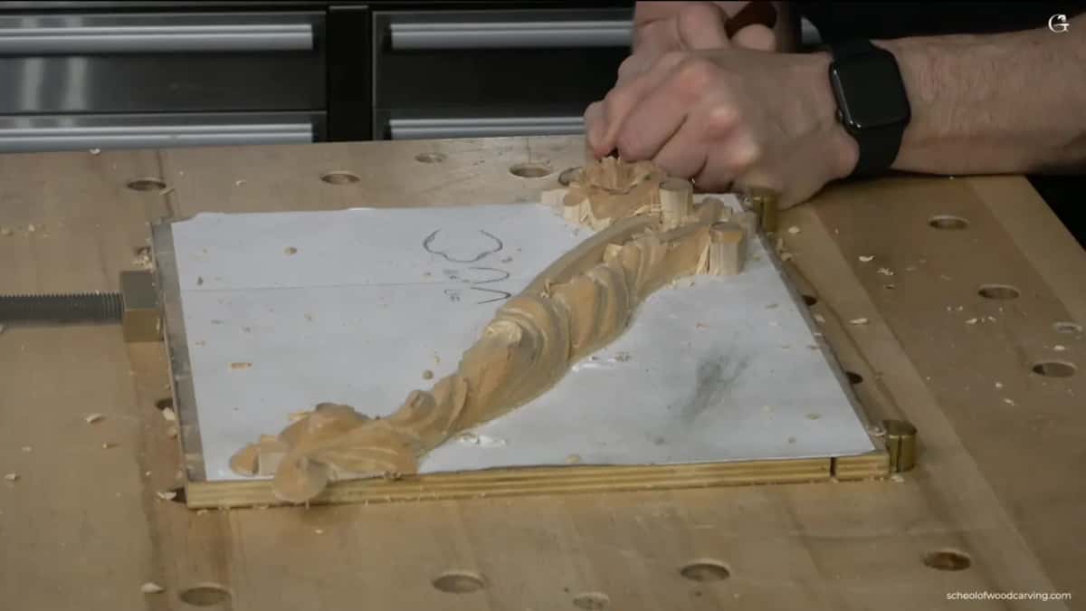 Whole panel on the bench, hands at the far edge, the flower end still rough.