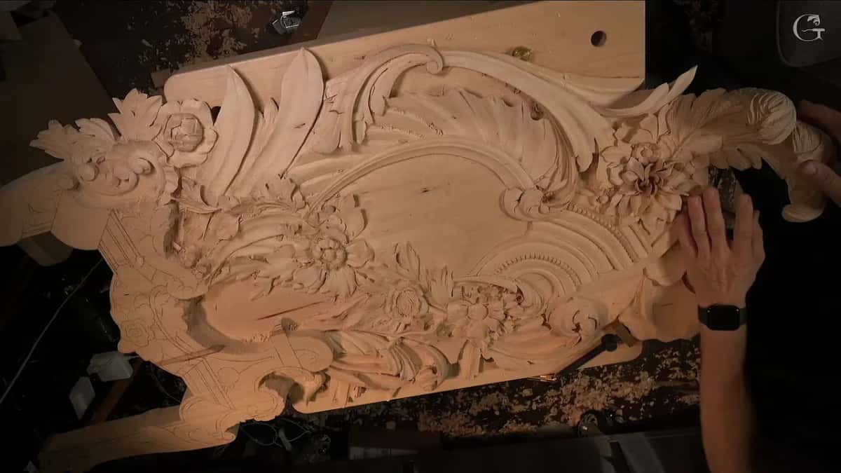 A right hand rests on the big carved flower near the top of the finished section