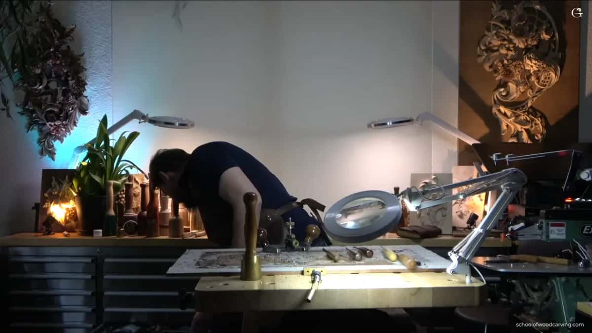 Bent over the bench, working.
