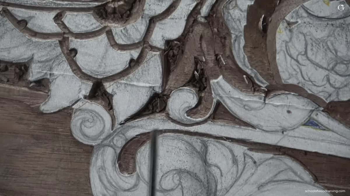 Thin steel shaft lying across the carved leaves.