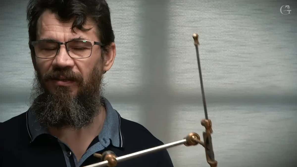 Needle held by two brass collars on the arm