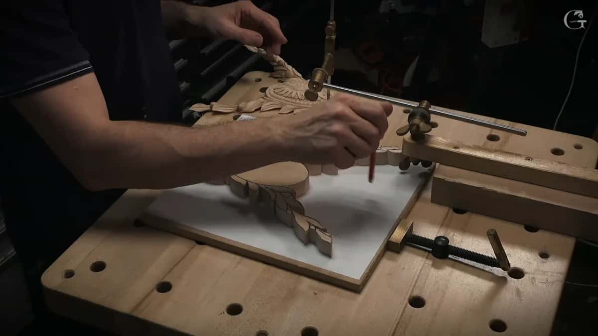 Needle set against the carved rosette to take one height off the model, a pencil ready in the other hand