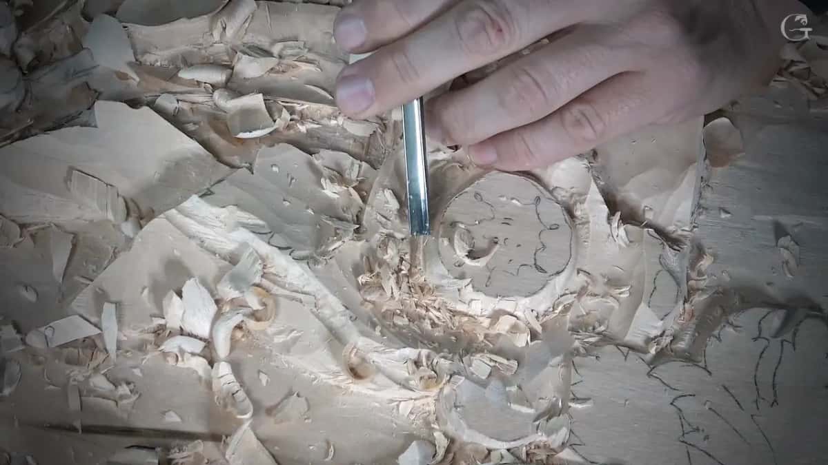 Slim gouge held upright at the flower's rim