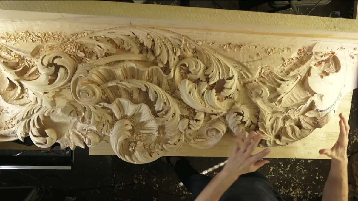 Both hands spread above the long carved board.