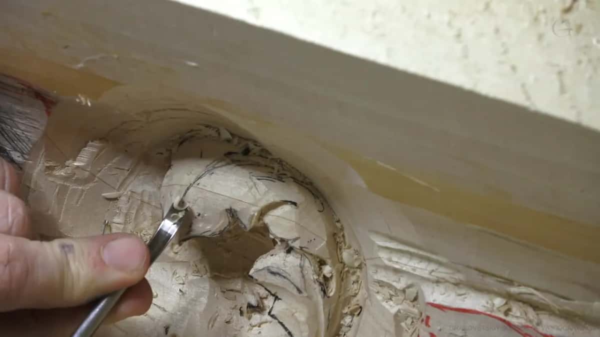 Small bent gouge between two fingers at the edge of the curve, the band just above it.