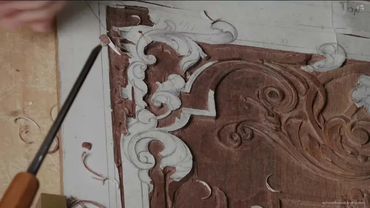 A long gouge laid across the corner, pointing in at the ornament.