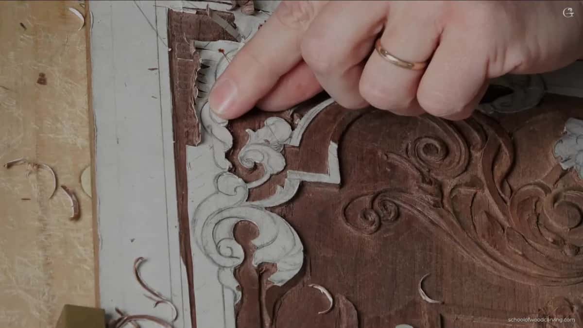 Fingers spread flat on the carving.