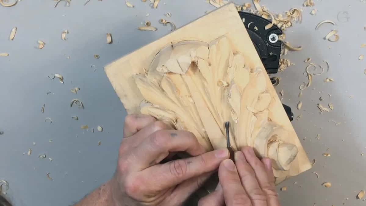 Overhead, both hands carrying one small gouge the whole width of the leaf