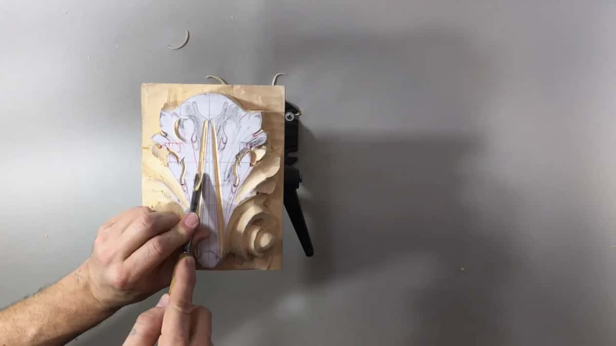 Both hands steer a narrow blade up the stem's left side