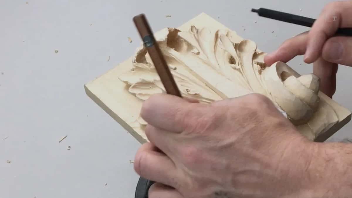 Long brown handle coming in low from the left of frame