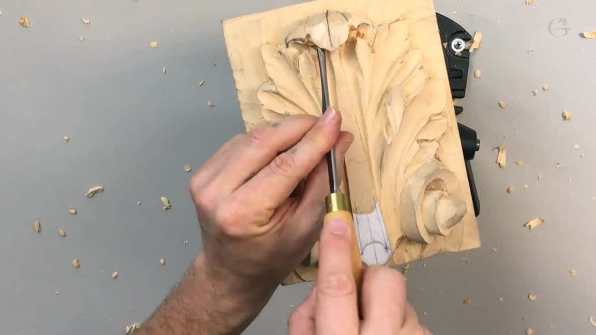 Brass ferruled tool pointing straight down into the hollow, held in both hands