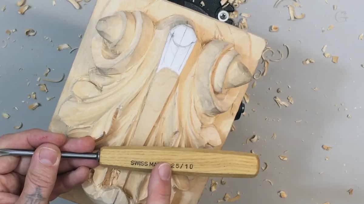 Stamped SWISS MADE 25 slash 10 along the pale handle, held across the carving