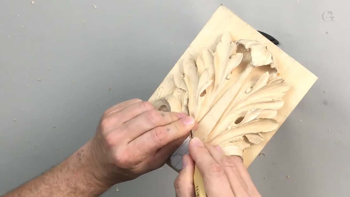 Both hands over the upright board, one fine blade between them