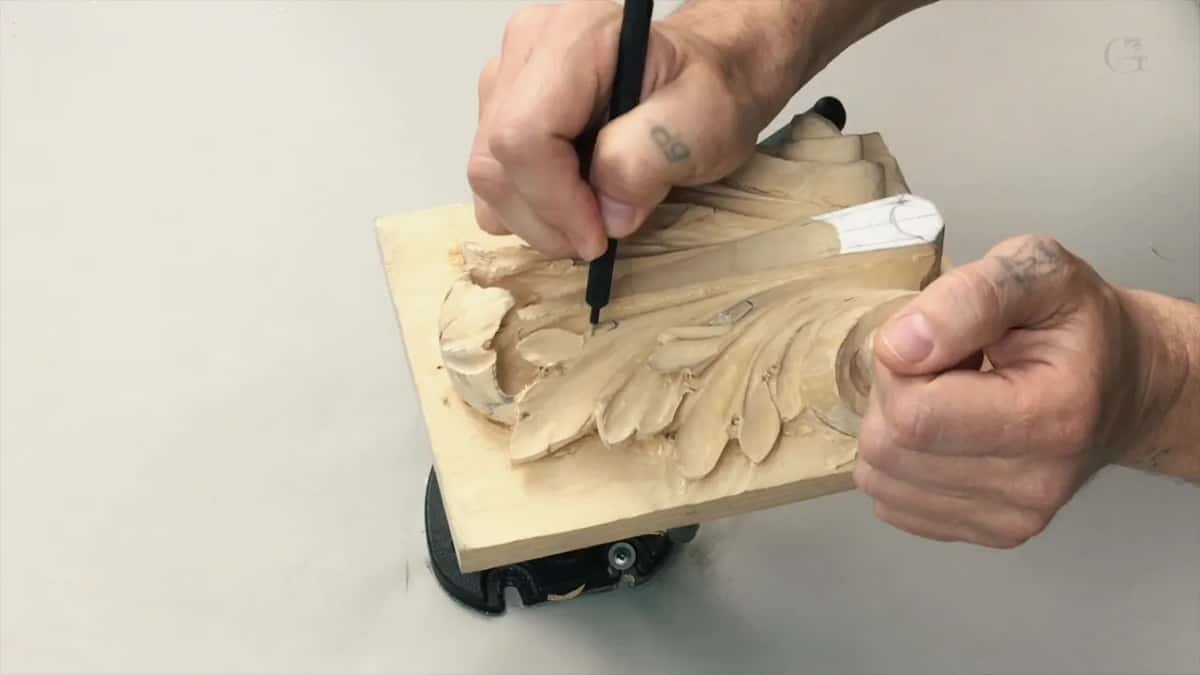 Both hands at the board, one holding the pencil at the top while the other steadies the far edge