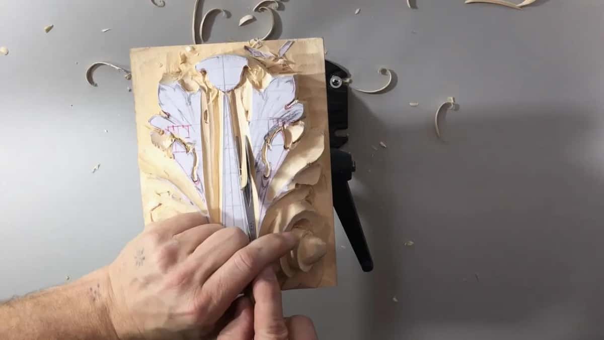 One finger beside a narrow tool deep in the groove right of the stem