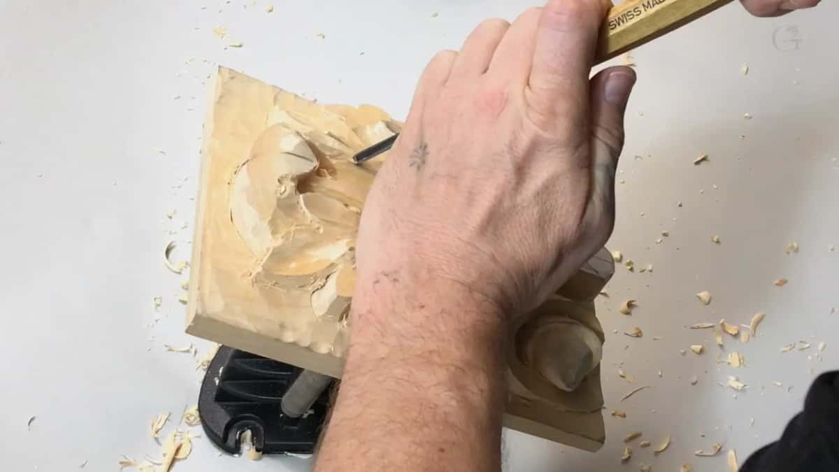 Brass ferrule and a thin V tool going into the centre of the acanthus, shavings all round the board