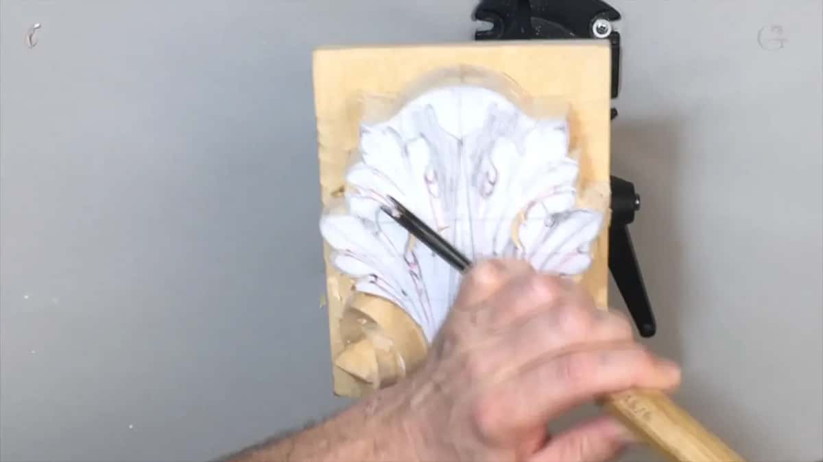 Light handle in the right hand, its blade reaching the lower right lobes beside the volute