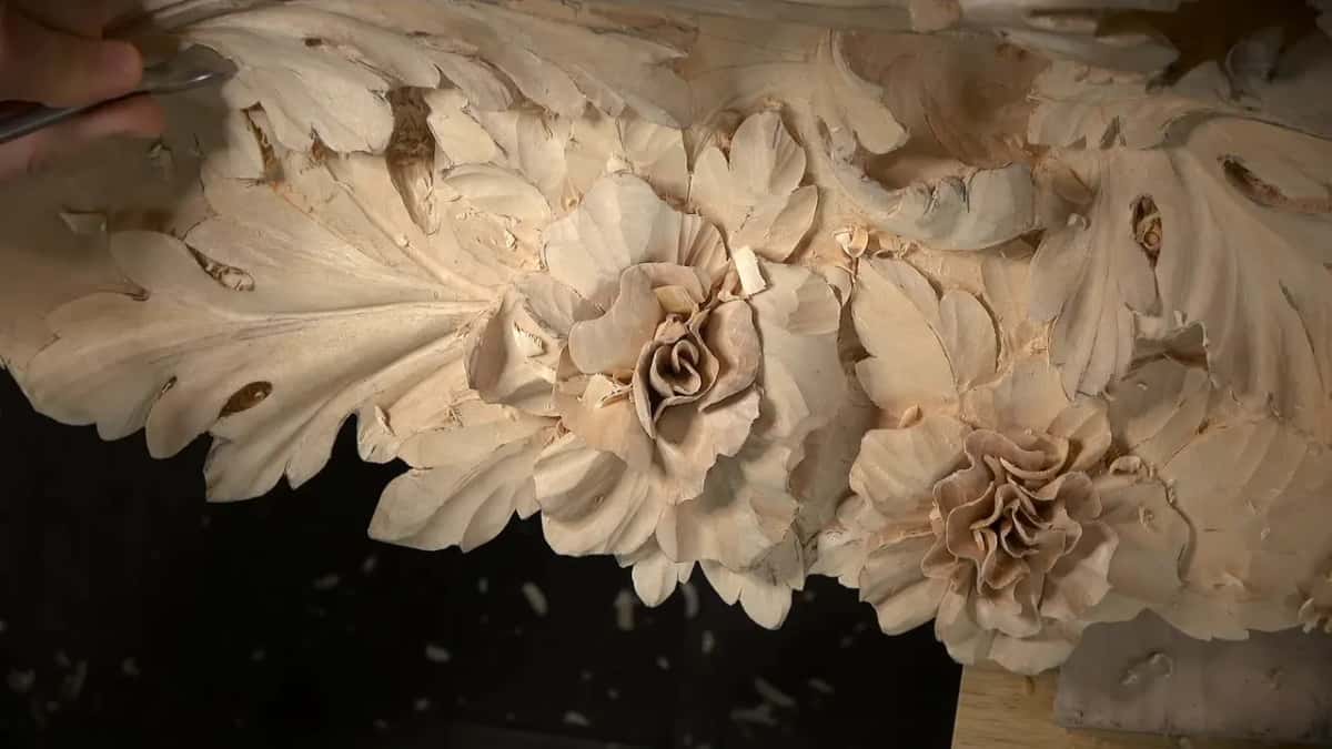 Carved roses and leaves along the panel's lower edge, a tool tip at top left