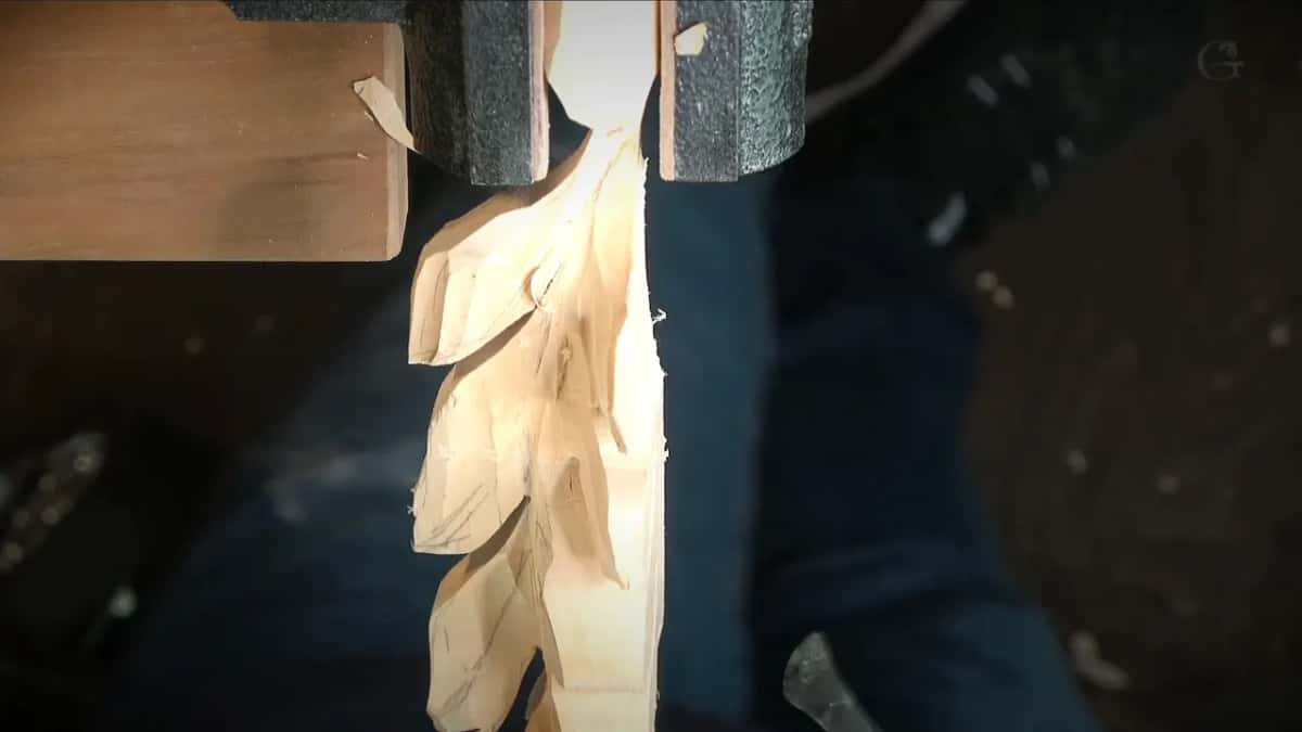 Roughed leaves stacked down the clamped stem, bare wood, nothing cleaned yet