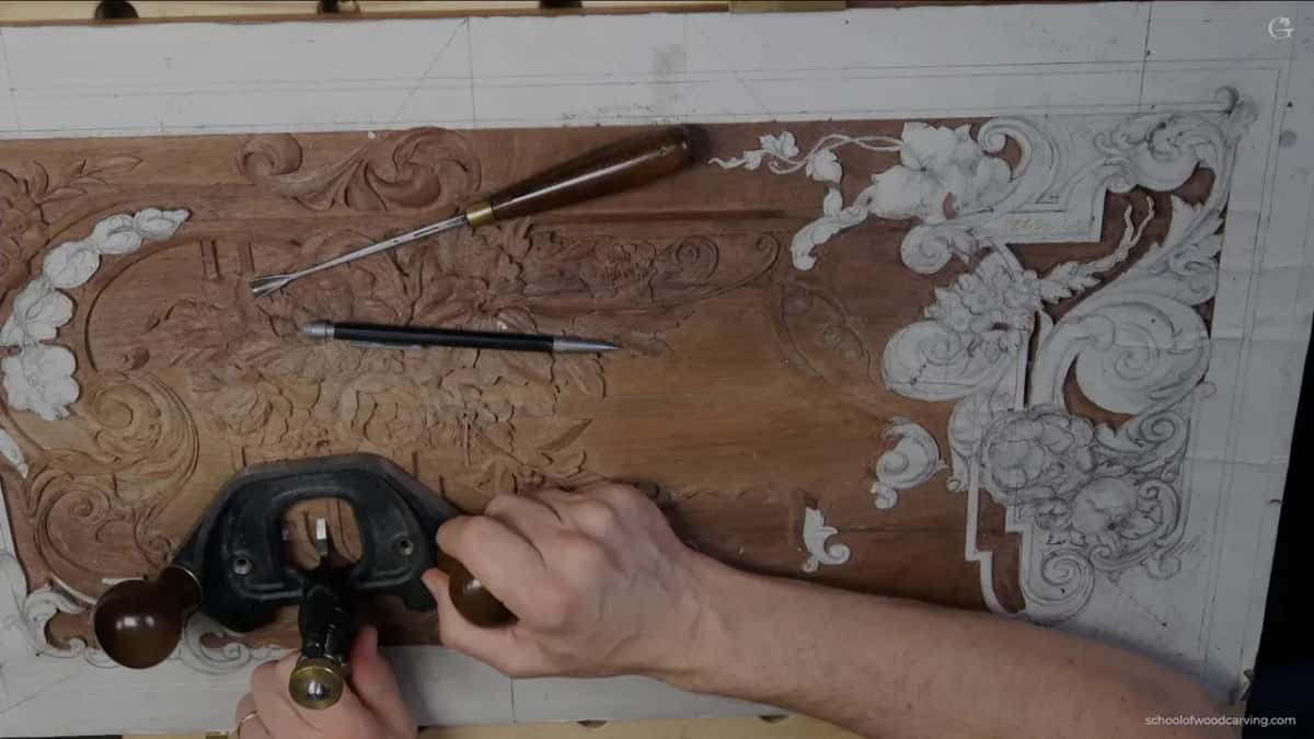 Panel from above with a gouge and a pencil across it, plane coming in below.