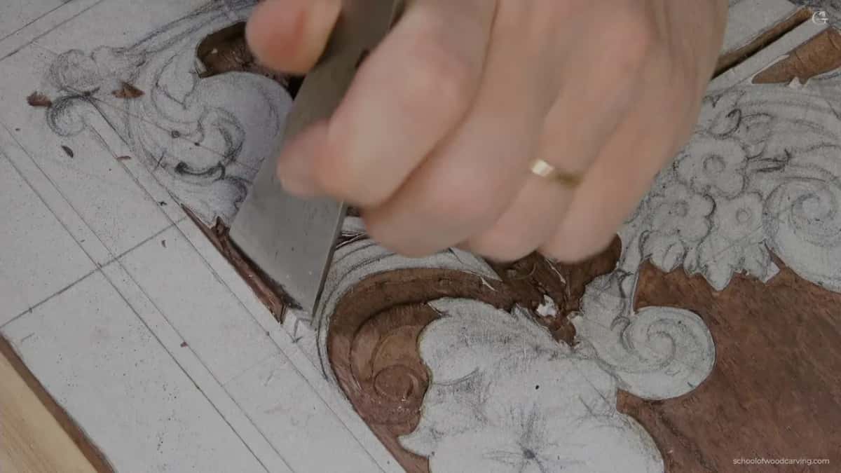 Wide flat chisel in my hand above the folded shape, about to be laid on the line.