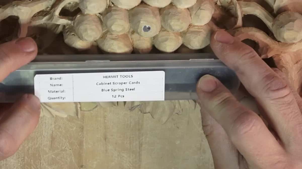 Package of scraper cards held over the carving.