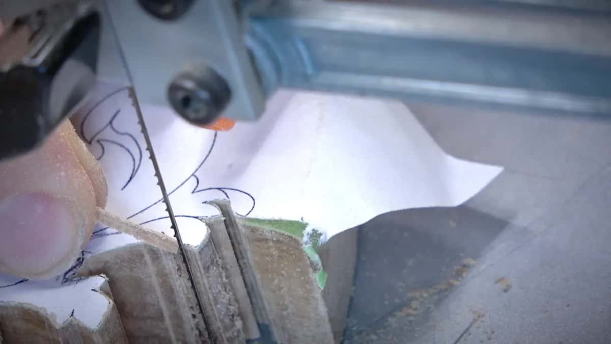 A very thin sliver Thin olive strip, 1/64 in (0.4 mm), standing beside the blade
