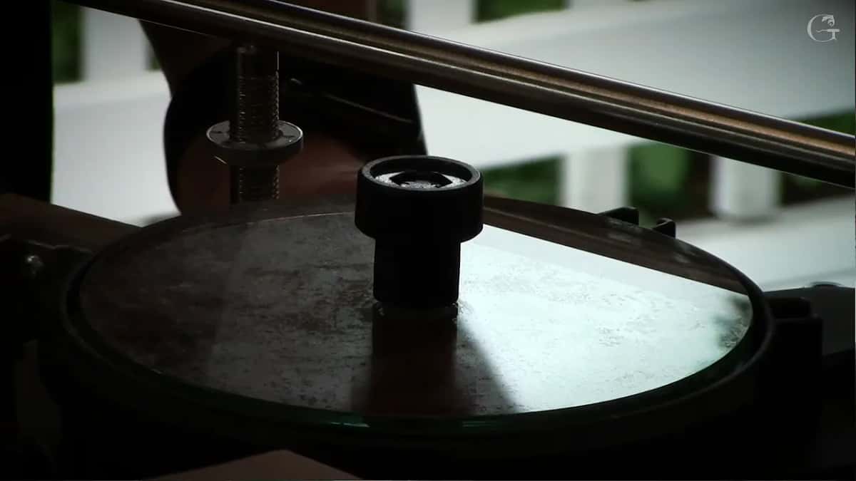 Abrasive disc half lifted off the glass wheel, centre knob loosened