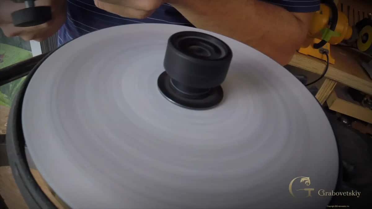 Pale abrasive turning, his hands at the far side.