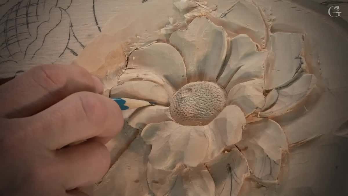 Close view of the flower, punched middle and cupped petals, a hand pointing at one petal with a pencil