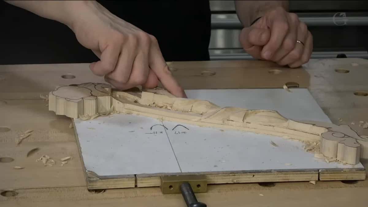 Both hands over the scroll, working out how low the leaf beside it has to sit.