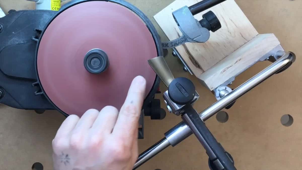A finger points at the middle of the turning disc, where it cuts gentlest.