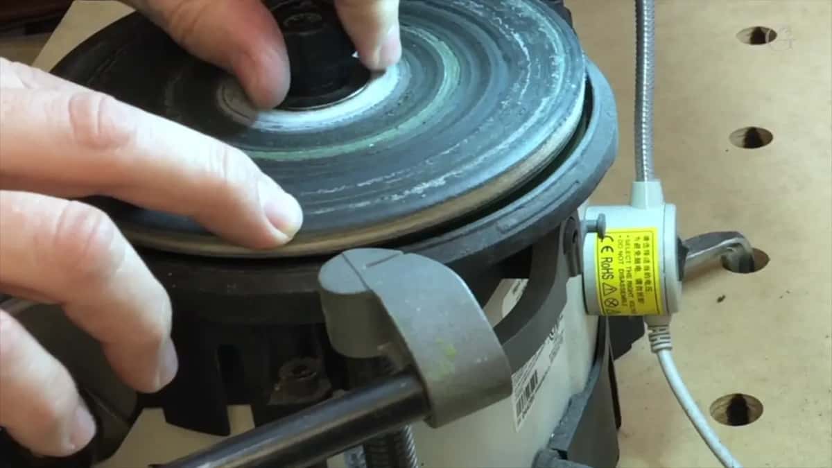 Two wheels stacked on one spindle, with green compound smeared right across the face of the upper one.