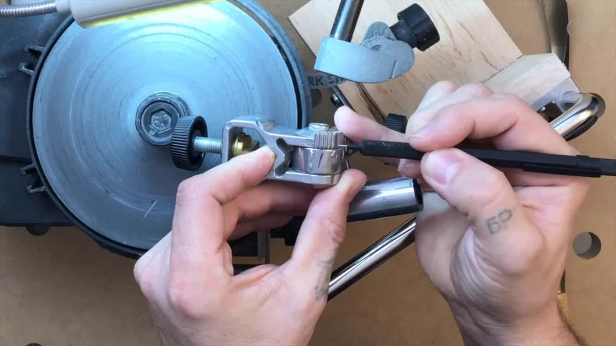 Both hands fitting the shank into the jig above the disc.