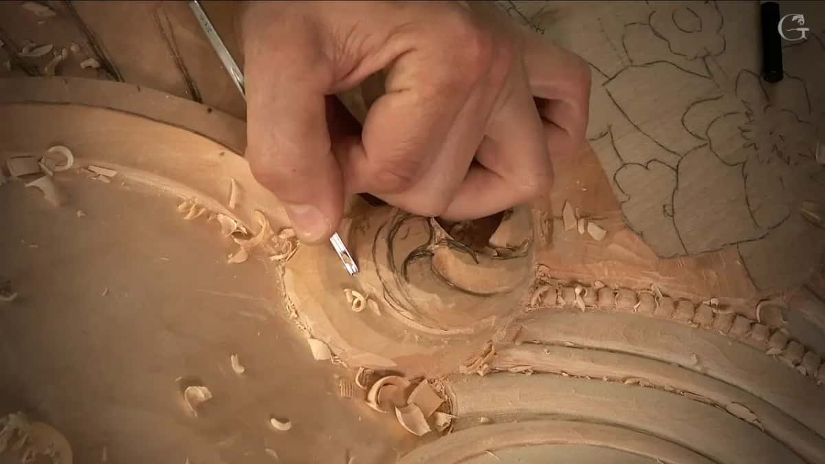 A narrow veiner goes into the pencilled spiral of a scroll, a run of carved beads just below it