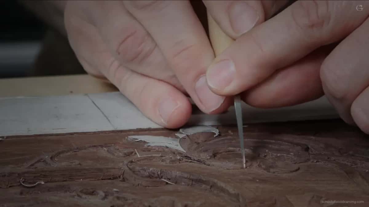 Pale handled knife held vertically, scraping rather than carving.