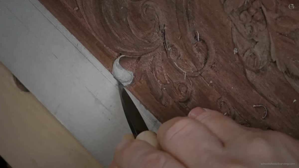 Both hands on a knife, drawing the line that is the life of the moulding.
