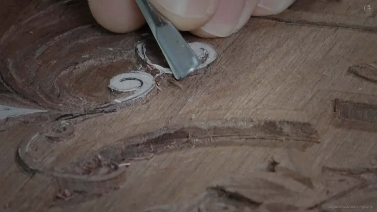 Blue grey blade arriving low and flat against the carving.