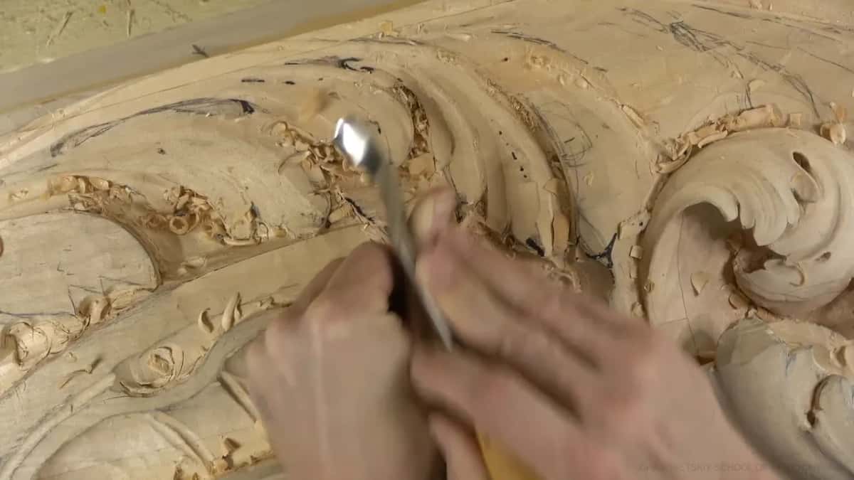 Both hands steer a slim metal tool into a hollow.