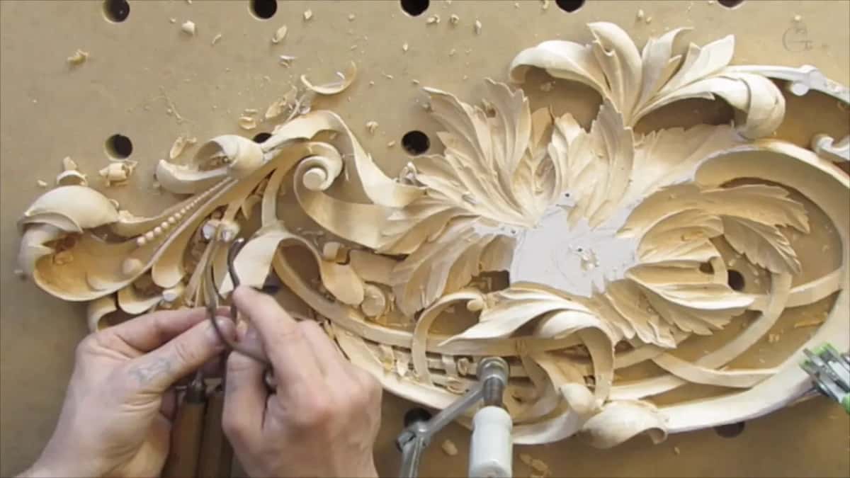 Second bend shown against the carved scrollwork, close enough to read its curve.