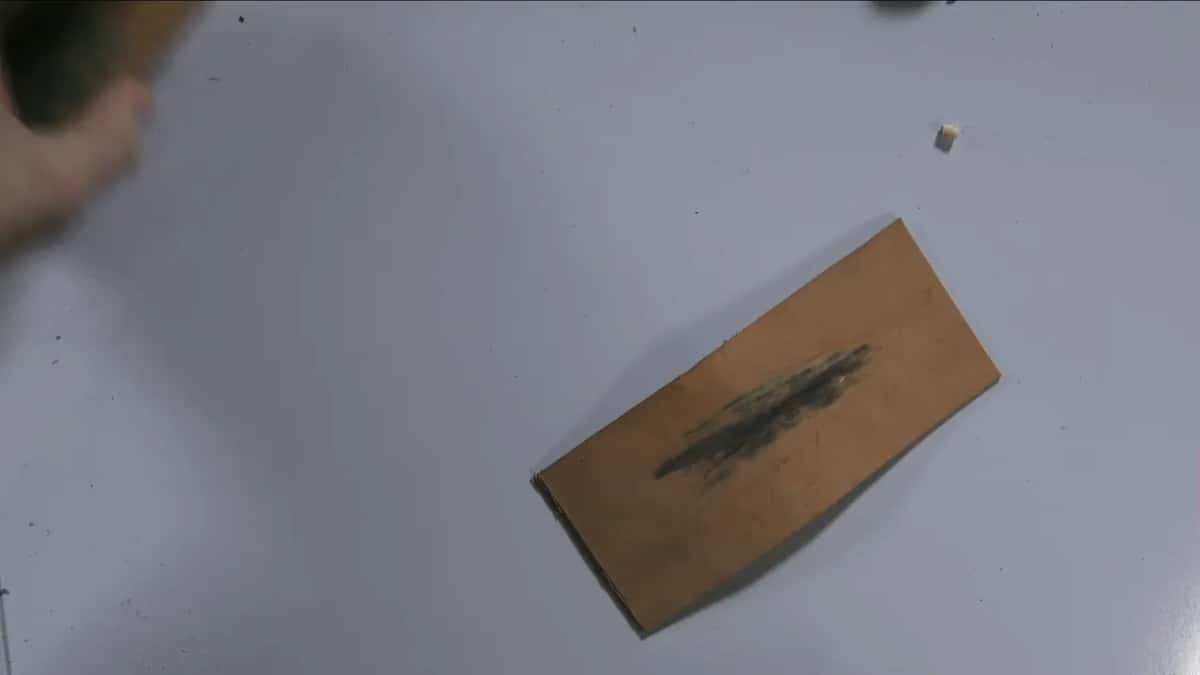 A dark smear runs down the middle of the tan leather, which is steel that has come off the tool.