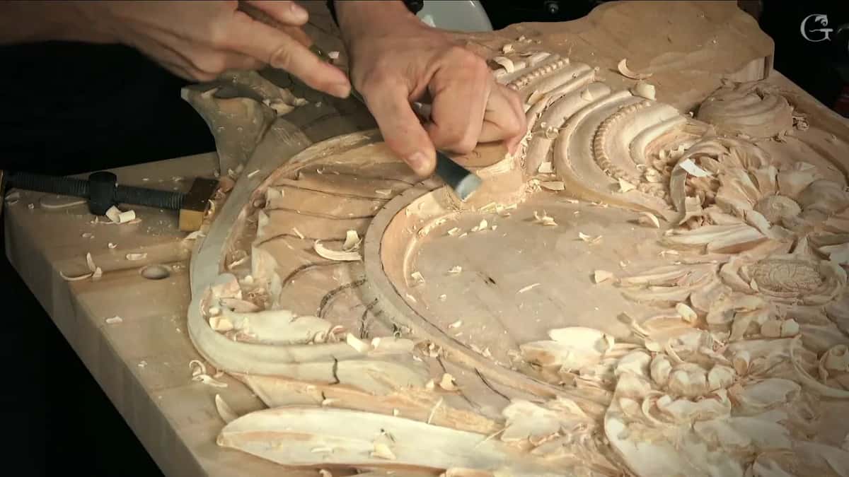 From the side, two hands press a flat tool on the rim close to the ribs