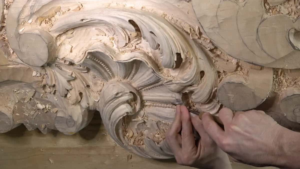 Wide view of the shell and its row of beads, two hands low on the band with a small gouge.