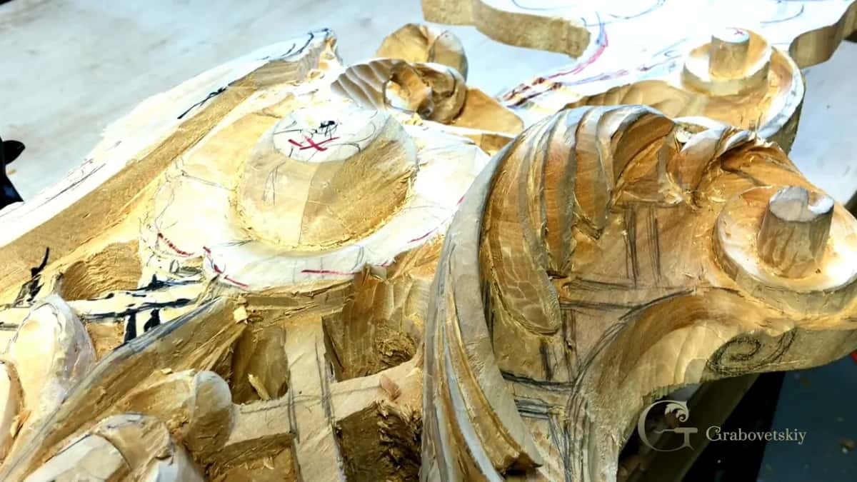 Scrolls and leaves cut deep in the gilded panel.